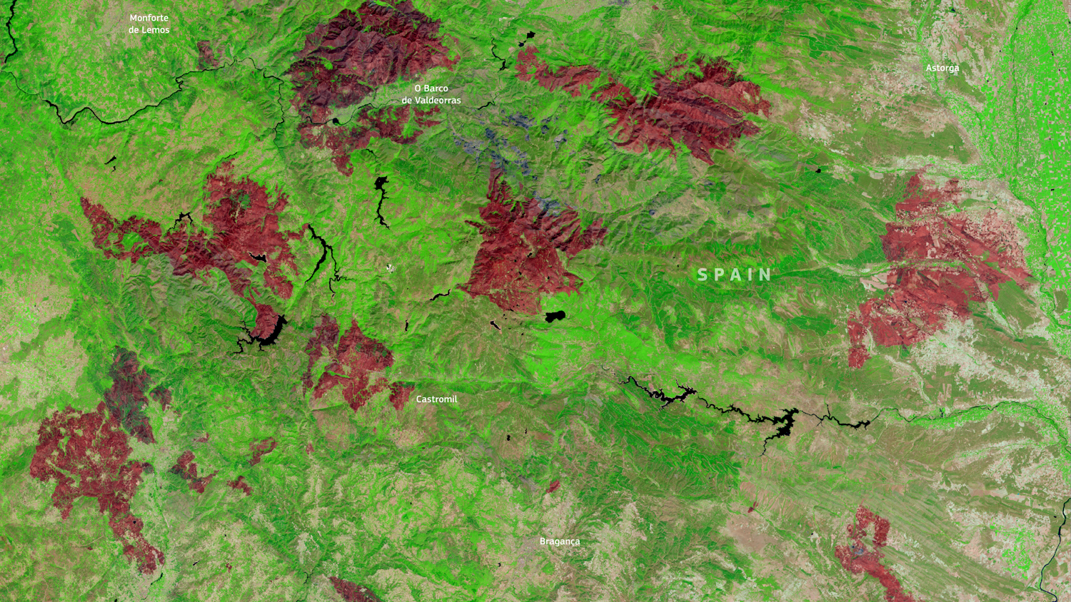 Satellite image of a region on the Spain-Portugal border showing areas in red, possibly indicating recent wildfires or burn scars, amidst green and brown landscape. Labels mark locations and borders.