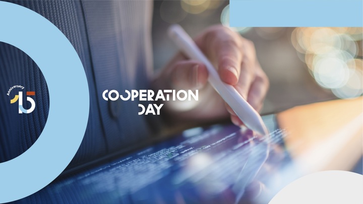 A close-up of a hand using a stylus on a touchscreen, with the words "Cooperation Day" and a colorful "15th anniversary" logo overlaid on a blue and white background.