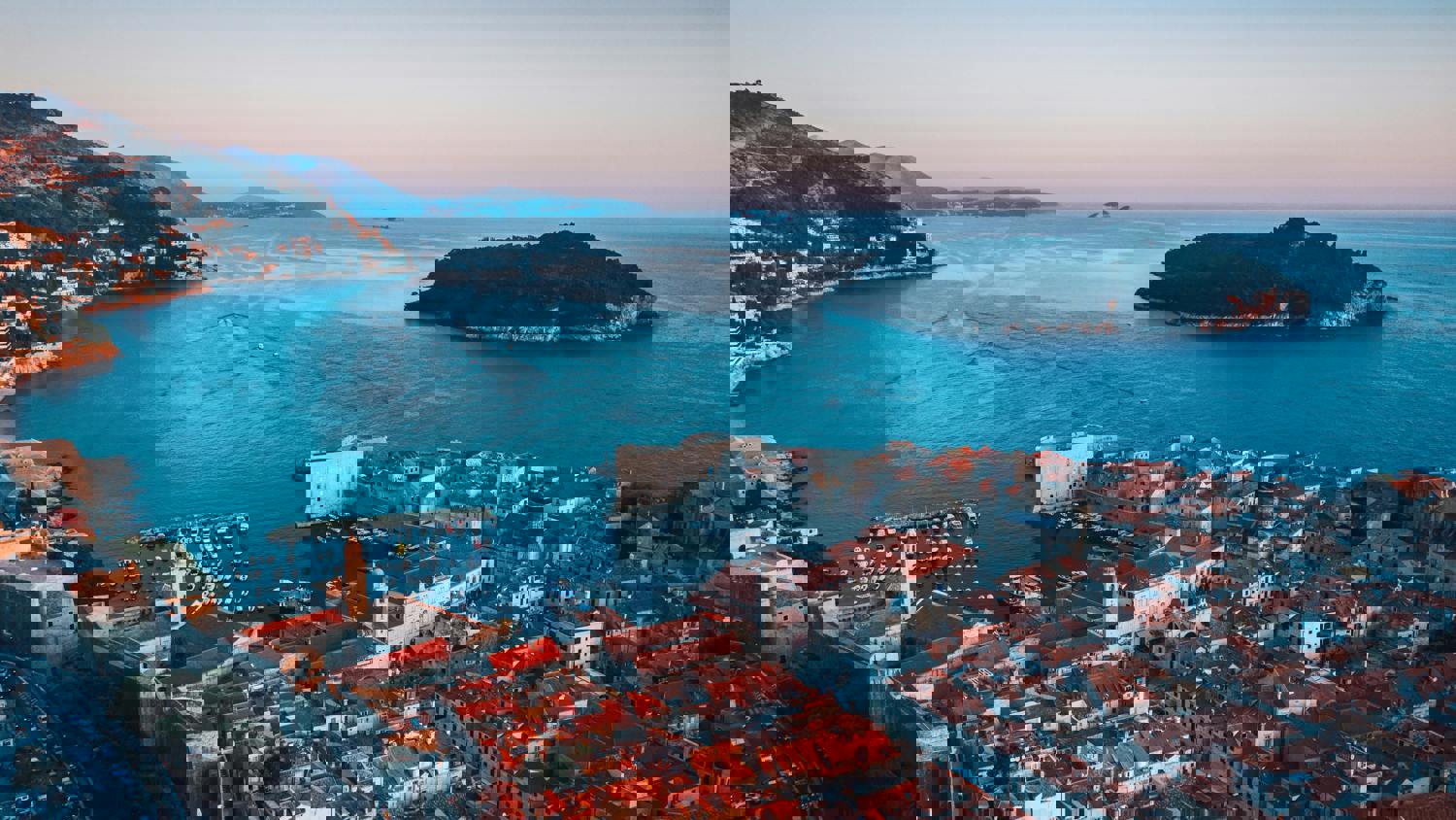 A coastal landscape with islands and buildings, digitally glitched with horizontal and pixelated distortions in blue and red tones, creating an abstract effect.