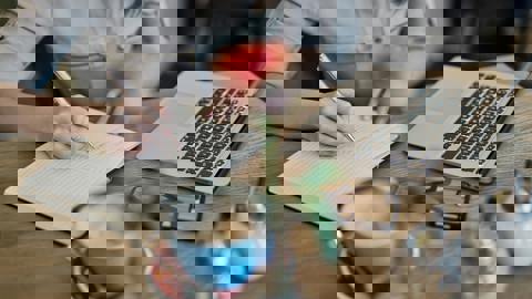 A digital image with heavy visual distortion, showing colorful horizontal glitches in purple, green, blue, and pink, making the original content difficult to identify.