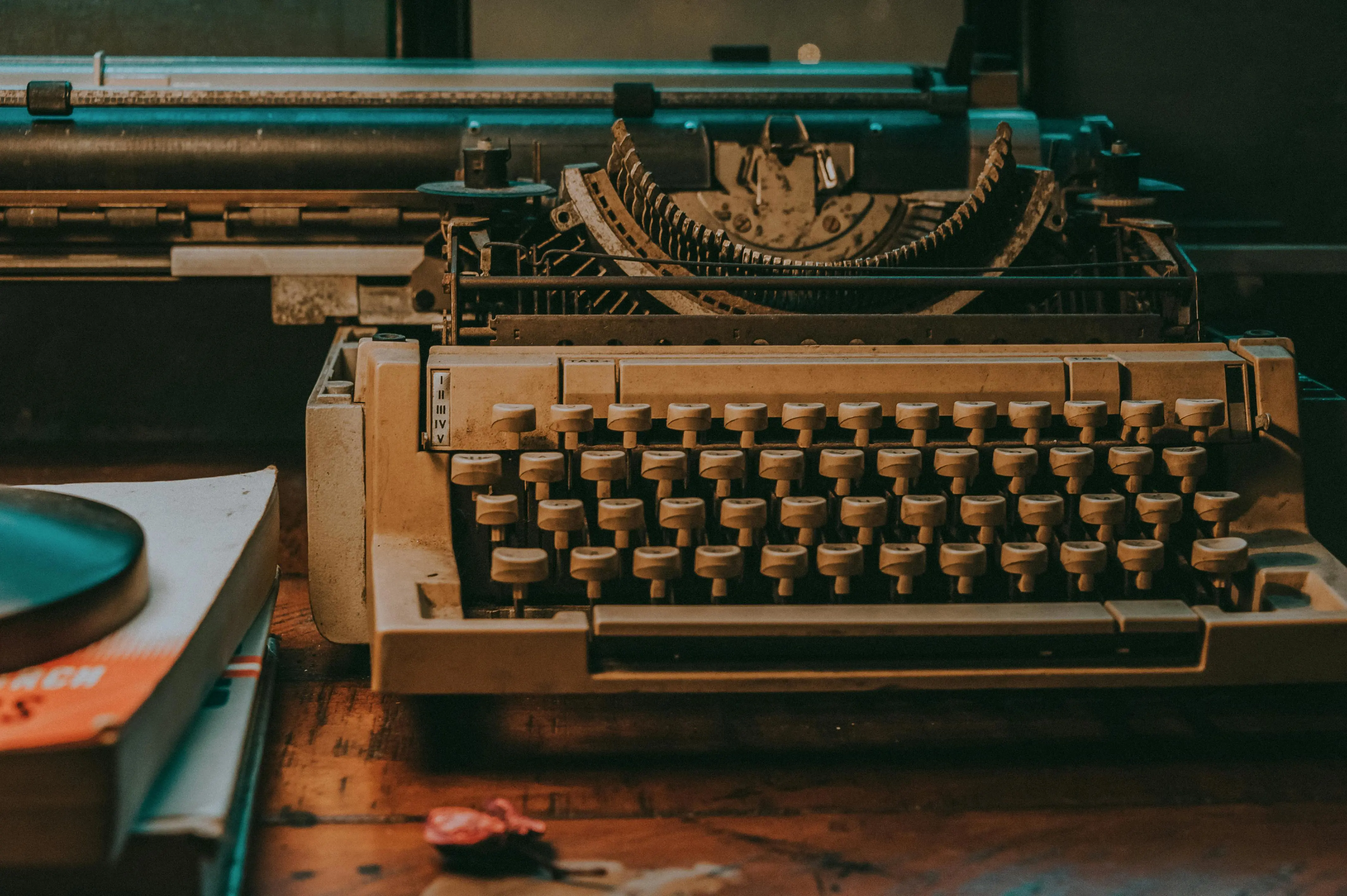 Three vintage typewriters are displayed side by side on a wooden surface. The image is heavily distorted with glitch effects, creating horizontal lines and color shifts that obscure details.