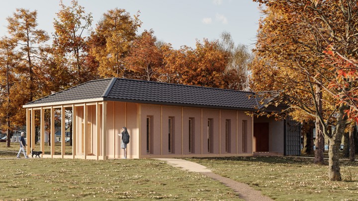 A single-story house with a dark roof and beige walls stands among autumn trees. A path leads to the entrance. Two people and a dog are visible near the house. The ground is covered with fallen leaves.