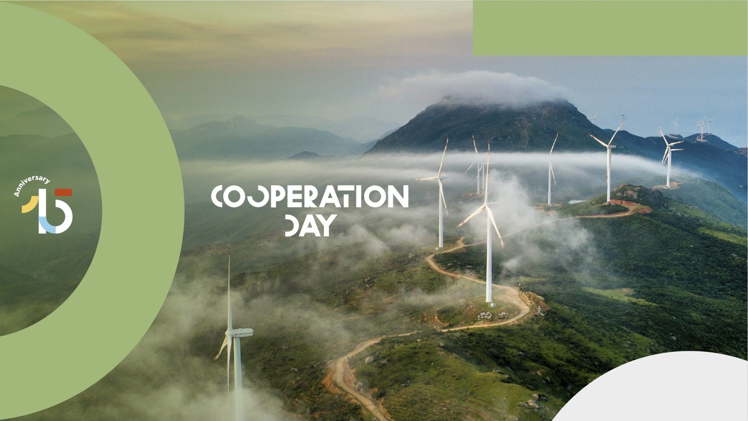 Aerial view of wind turbines on a green, misty mountain landscape. "Cooperation Day" text overlays the scene. On the left, a stylized "75" anniversary logo appears on a light green background.