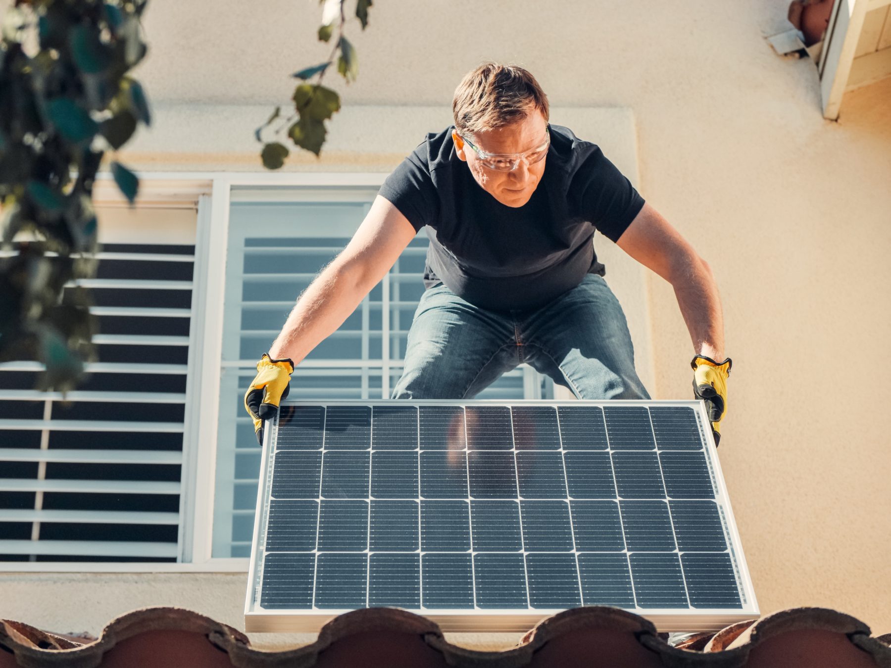 A man with a solar panel (relevant for SunPeople project). Available on Pexels.com, provided by Kindel Media.